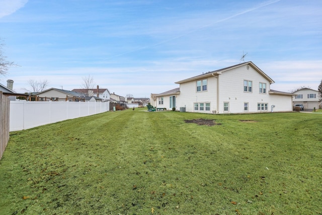 rear view of property with a lawn and fence