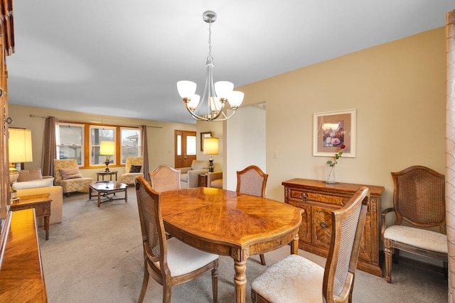 dining area featuring an inviting chandelier and light carpet