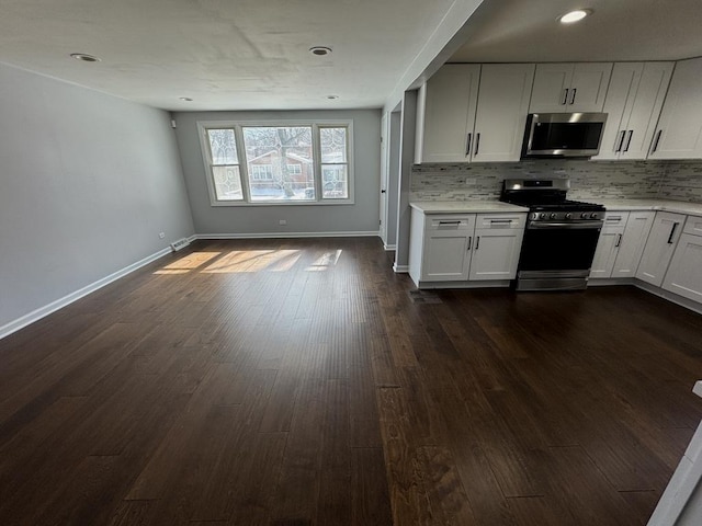 kitchen with baseboards, decorative backsplash, dark wood-style floors, stainless steel appliances, and light countertops