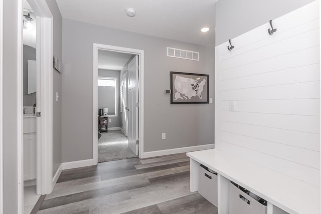 mudroom featuring wood finished floors, visible vents, and baseboards