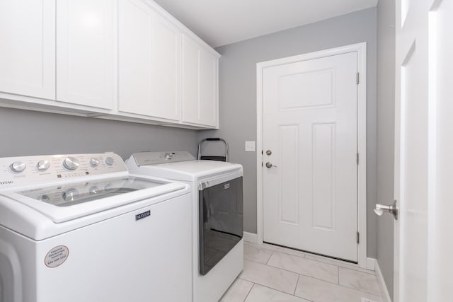 laundry room with washer and clothes dryer, cabinet space, and baseboards