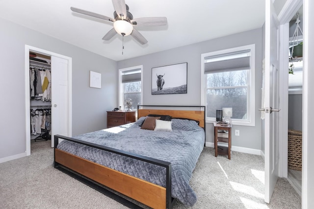 carpeted bedroom with a closet, baseboards, and a ceiling fan