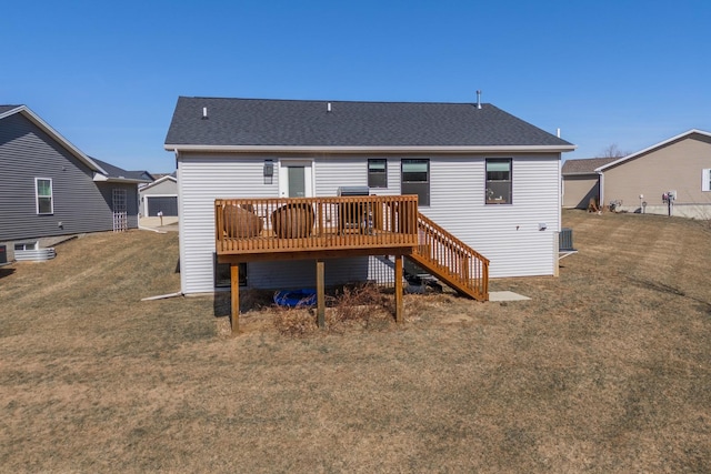 rear view of property with a wooden deck, a lawn, roof with shingles, and stairway