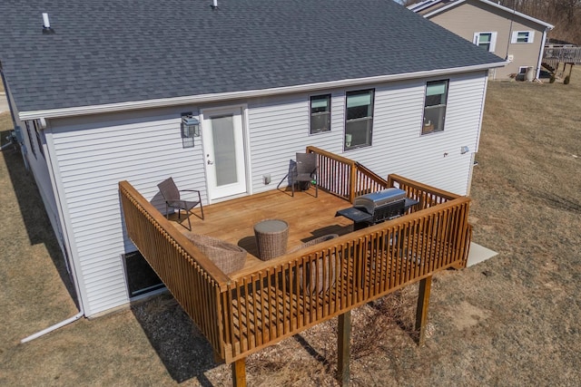 rear view of house with a wooden deck and roof with shingles