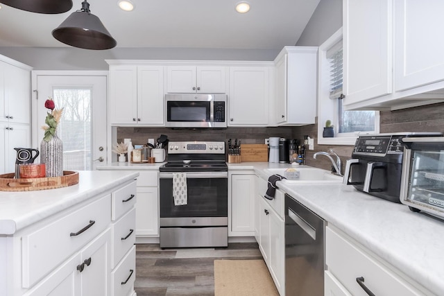 kitchen with white cabinets, backsplash, a healthy amount of sunlight, and appliances with stainless steel finishes