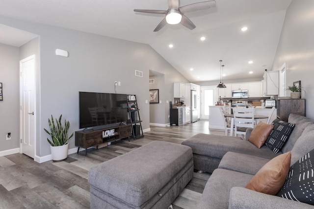 living area featuring visible vents, baseboards, wood finished floors, and a ceiling fan