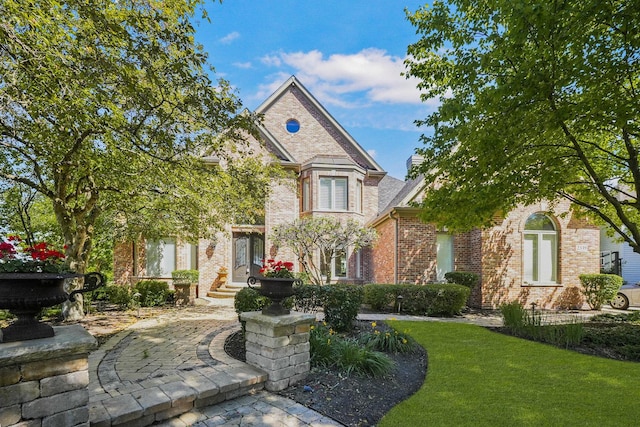 view of front facade featuring brick siding and a front yard