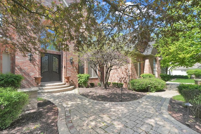 view of front of house featuring brick siding and french doors