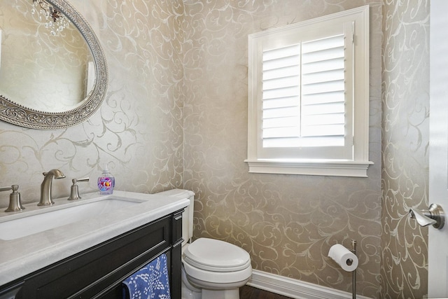 half bathroom with toilet, wallpapered walls, and baseboards