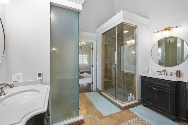 full bath with tile patterned floors, two vanities, a stall shower, and a sink