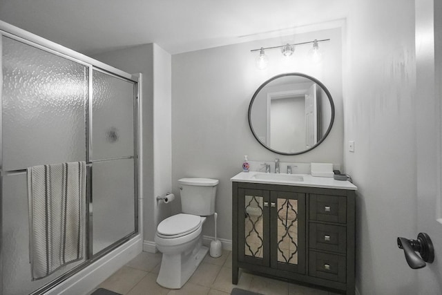 bathroom with vanity, baseboards, a stall shower, tile patterned floors, and toilet