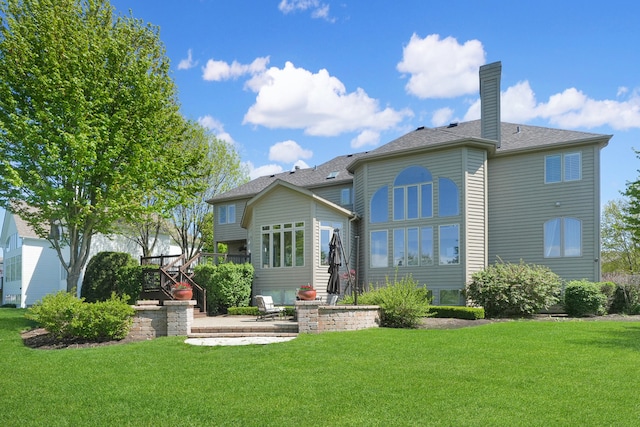 back of property featuring a patio, a lawn, and a chimney