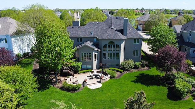 rear view of property with a yard, a chimney, and a patio