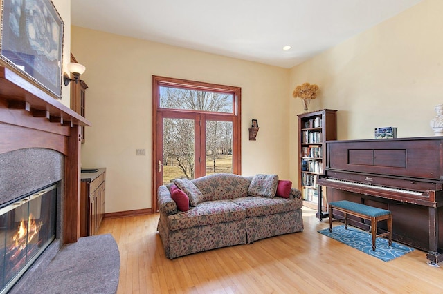 living room with a glass covered fireplace, recessed lighting, baseboards, and hardwood / wood-style flooring