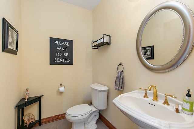 bathroom with a sink, baseboards, and toilet