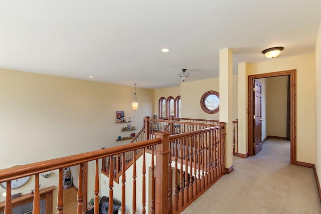 hallway with an upstairs landing, recessed lighting, light carpet, and baseboards