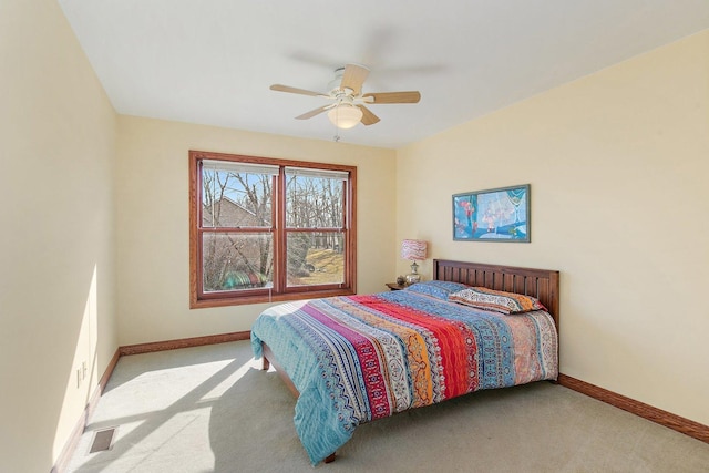 carpeted bedroom featuring visible vents, a ceiling fan, and baseboards