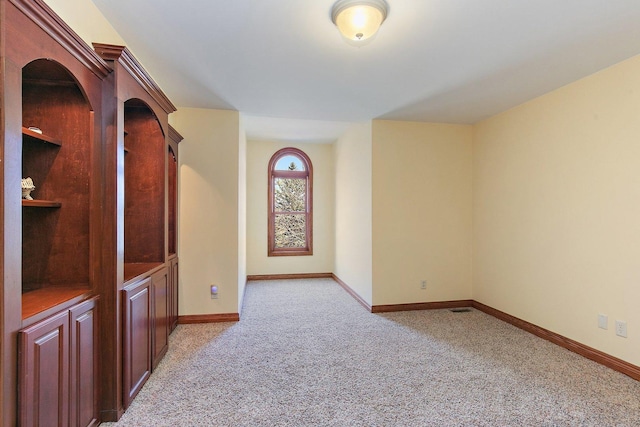 empty room with light carpet, visible vents, and baseboards