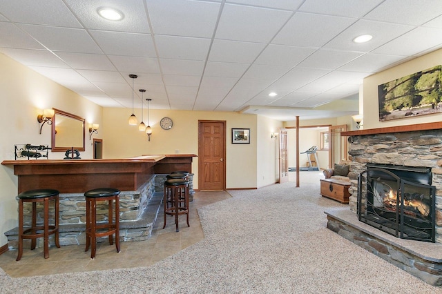 bar with baseboards, a drop ceiling, a dry bar, carpet flooring, and a fireplace