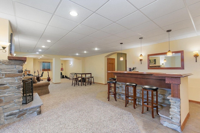 bar featuring baseboards, a dry bar, recessed lighting, arched walkways, and a paneled ceiling