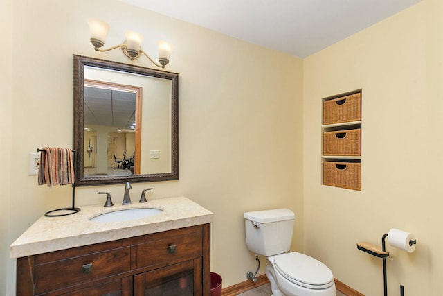 bathroom with vanity, toilet, and baseboards