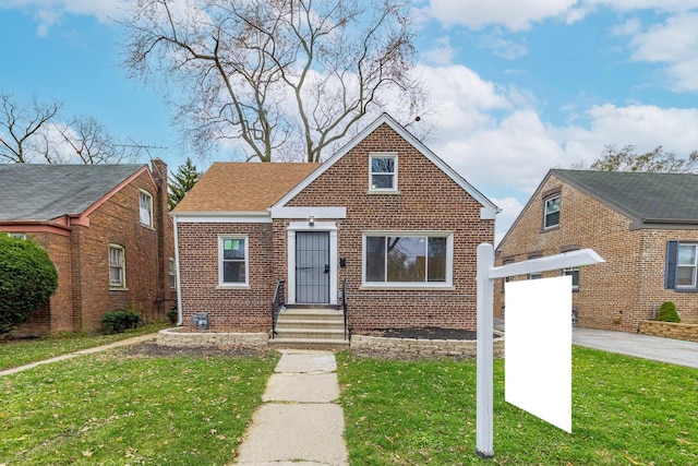 bungalow-style house featuring a front yard and brick siding