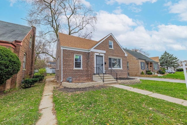 bungalow with brick siding, roof with shingles, and a front yard