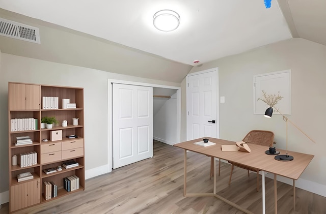 office with lofted ceiling, visible vents, light wood-style flooring, and baseboards