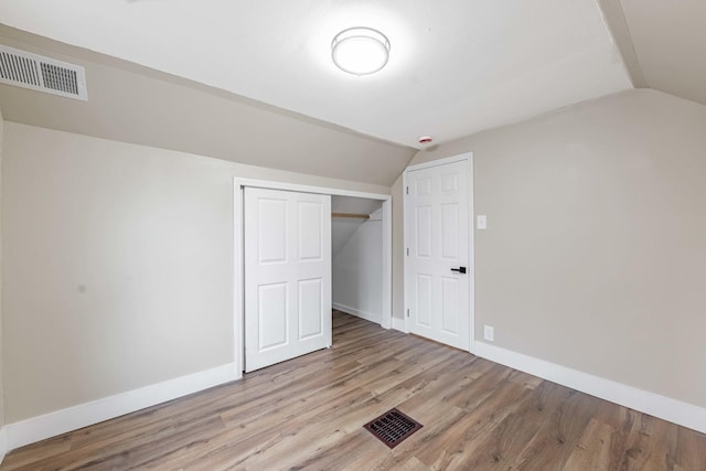 bonus room featuring lofted ceiling, light wood finished floors, visible vents, and baseboards