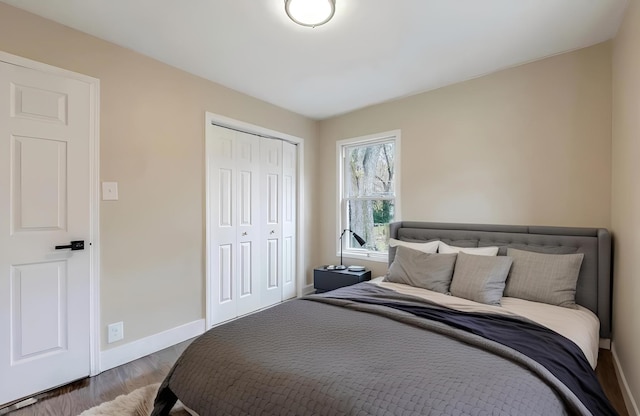 bedroom featuring a closet, baseboards, and wood finished floors