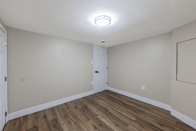 unfurnished room featuring baseboards and wood finished floors