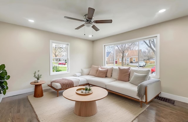 living room featuring recessed lighting, visible vents, baseboards, and wood finished floors