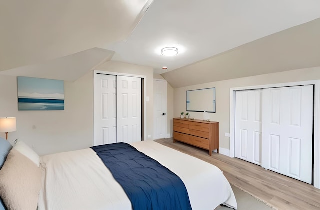 bedroom featuring vaulted ceiling and light wood finished floors