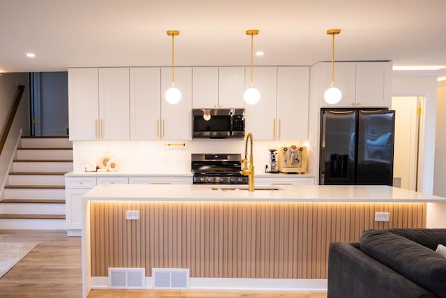 kitchen featuring stainless steel appliances, light countertops, a sink, and tasteful backsplash