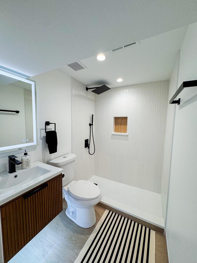 full bath featuring visible vents, vanity, walk in shower, and toilet