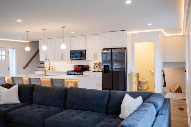 living area featuring stairway, wood finished floors, visible vents, and recessed lighting