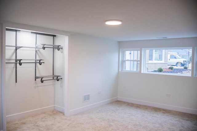 carpeted spare room with visible vents and baseboards