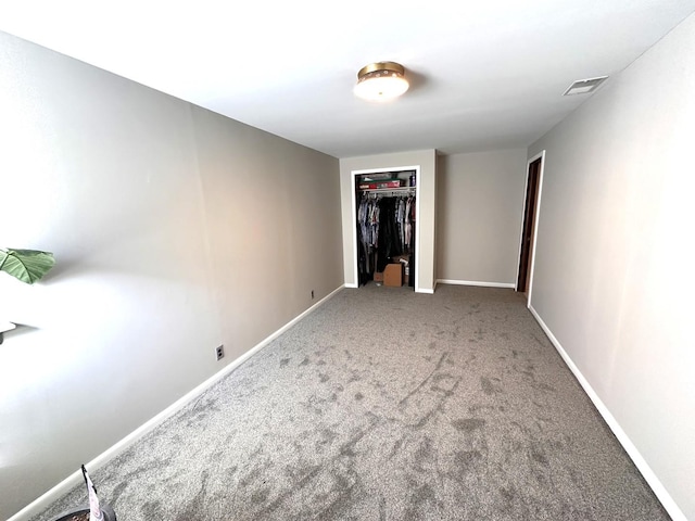 unfurnished bedroom featuring a closet, carpet flooring, visible vents, and baseboards