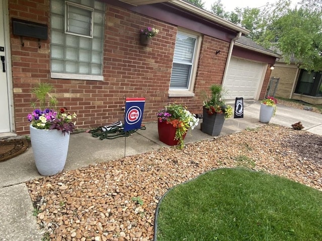 view of side of home with an attached garage, concrete driveway, and brick siding