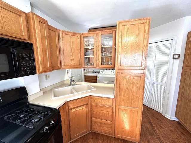 kitchen featuring glass insert cabinets, dark wood-style flooring, black appliances, separate washer and dryer, and a sink