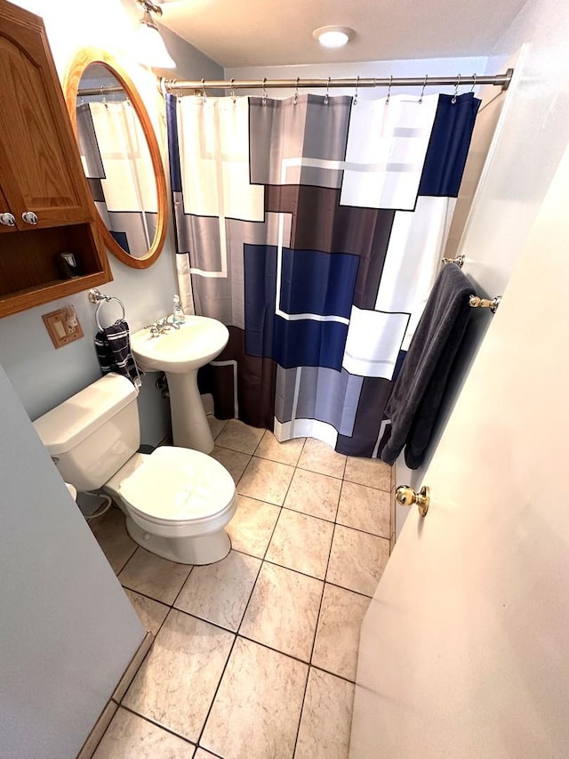 bathroom with curtained shower, tile patterned flooring, and toilet