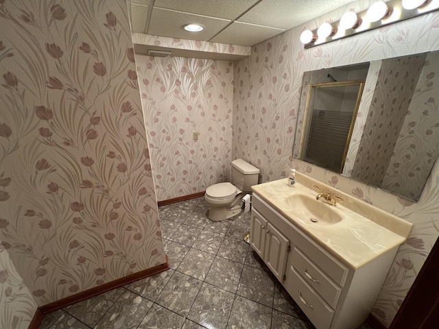 full bath featuring a shower stall, wallpapered walls, baseboards, toilet, and vanity