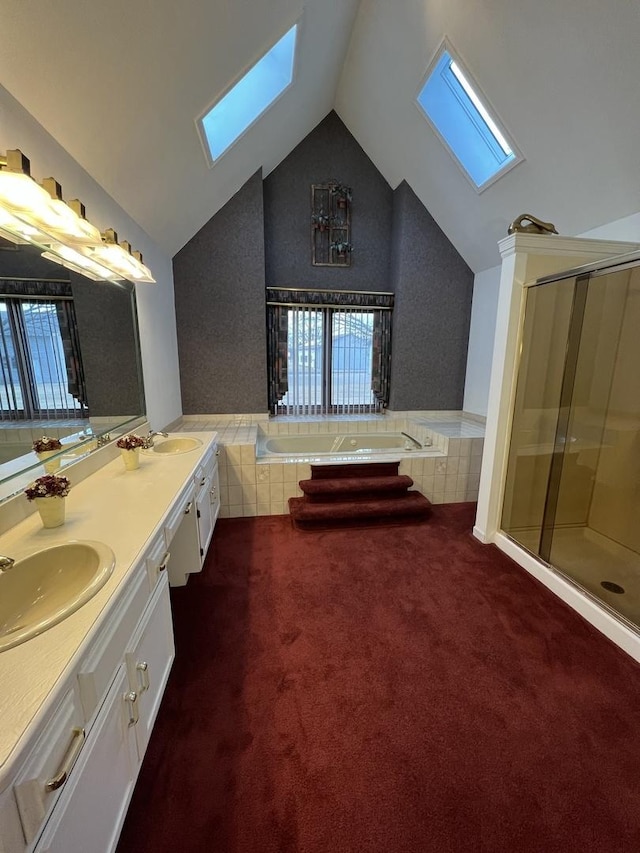 bathroom featuring a sink, lofted ceiling with skylight, a healthy amount of sunlight, and a bath