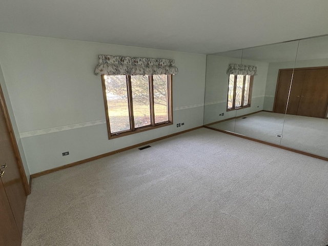 unfurnished bedroom with visible vents, baseboards, a closet, and carpet flooring