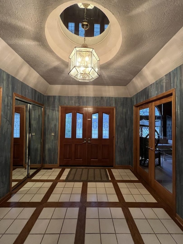 entrance foyer featuring tile patterned flooring, french doors, and a textured ceiling