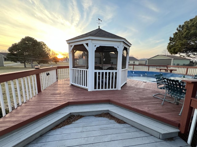 wooden deck featuring a covered pool and a gazebo