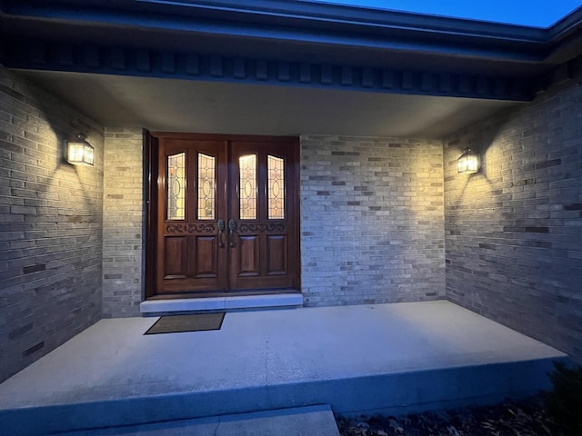 entrance to property with brick siding and a porch