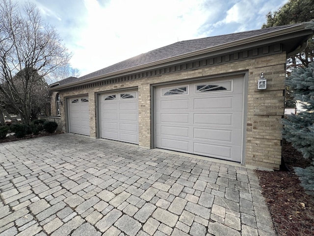 garage with decorative driveway