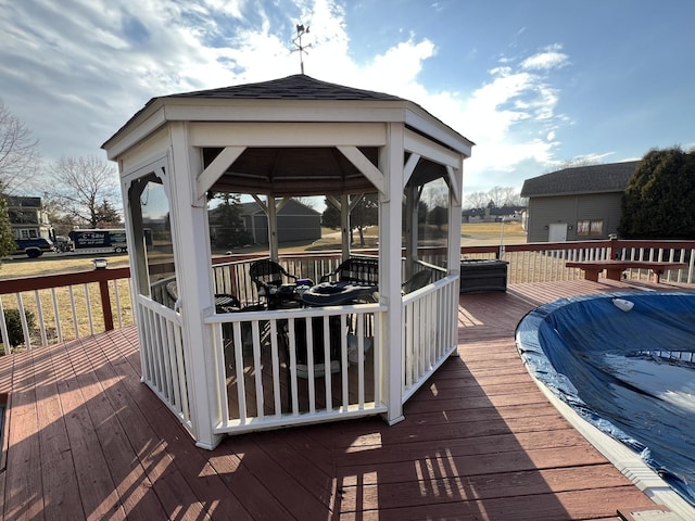 wooden deck with a gazebo and an outbuilding