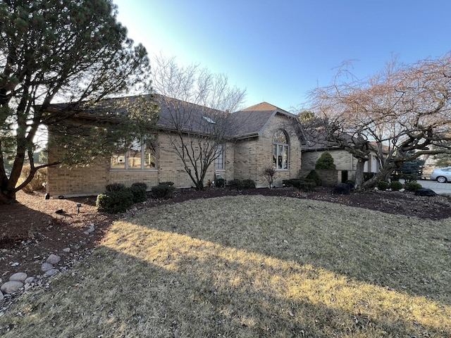 view of home's exterior with brick siding and roof with shingles